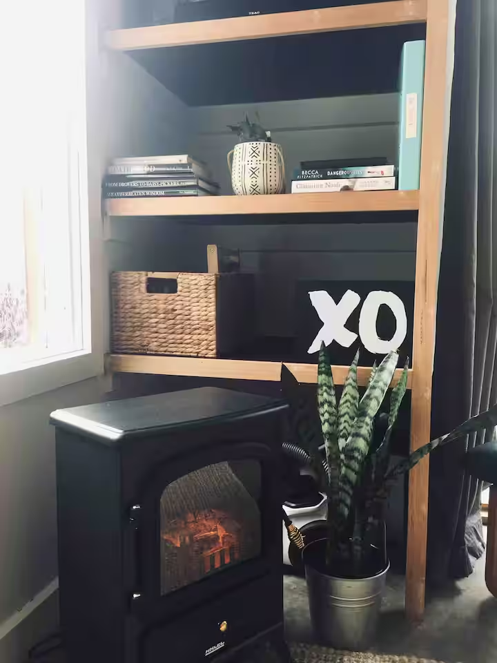Cozy fireplace nook with bookshelf and XO sign